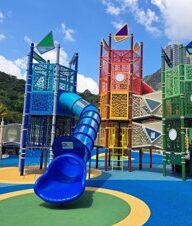 Tall play tower with a blue tube slide at Jordan Valley Park playground