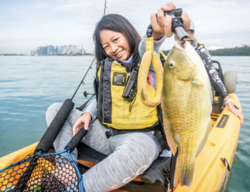 Happy family enjoying kayak fishing adventure in Sentosa, Singapore