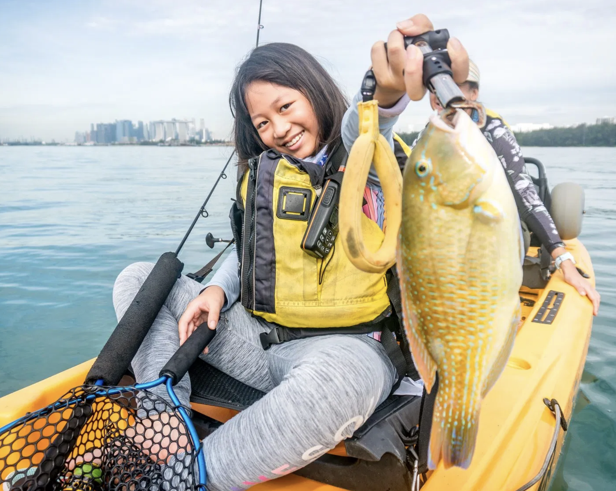 Happy family enjoying kayak fishing adventure in Sentosa, Singapore