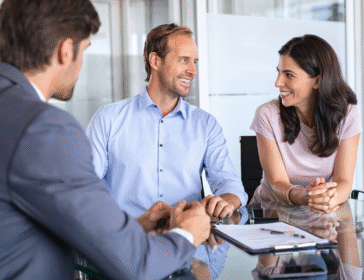 happy couple sitting at a table going over tax in Singapore