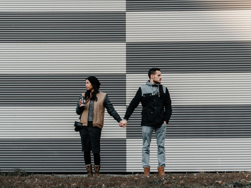 Image of couple holding hands and looking away from each other - divorce singapore