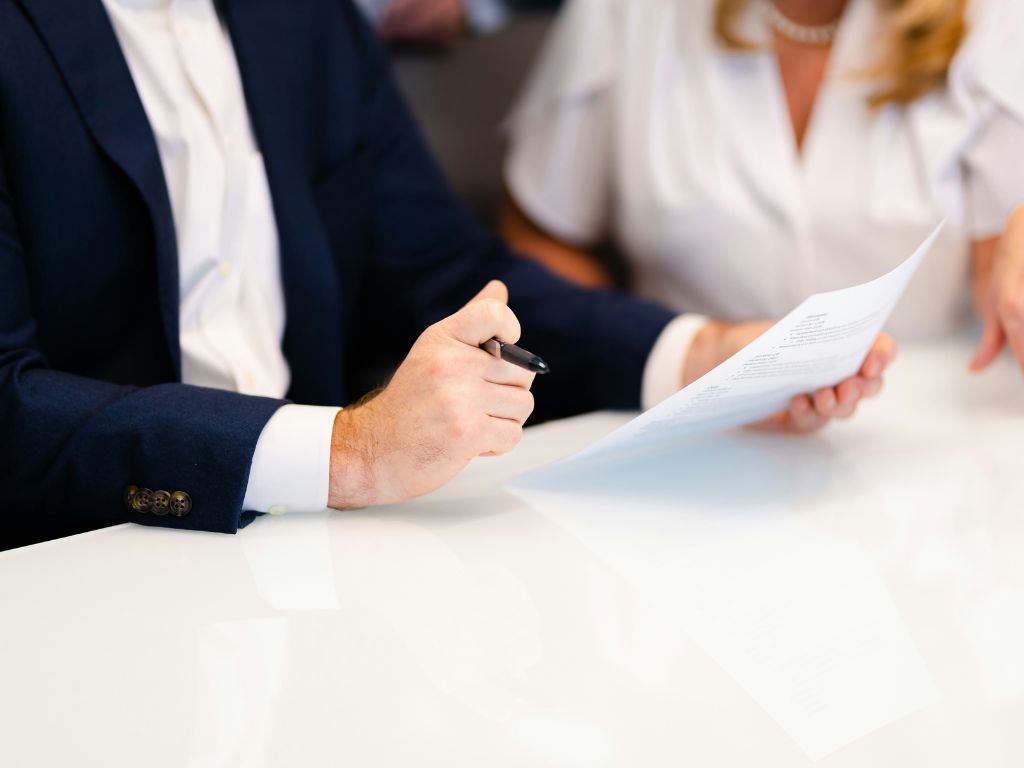 Image of man in suit holding a pen and document - divorce singapore