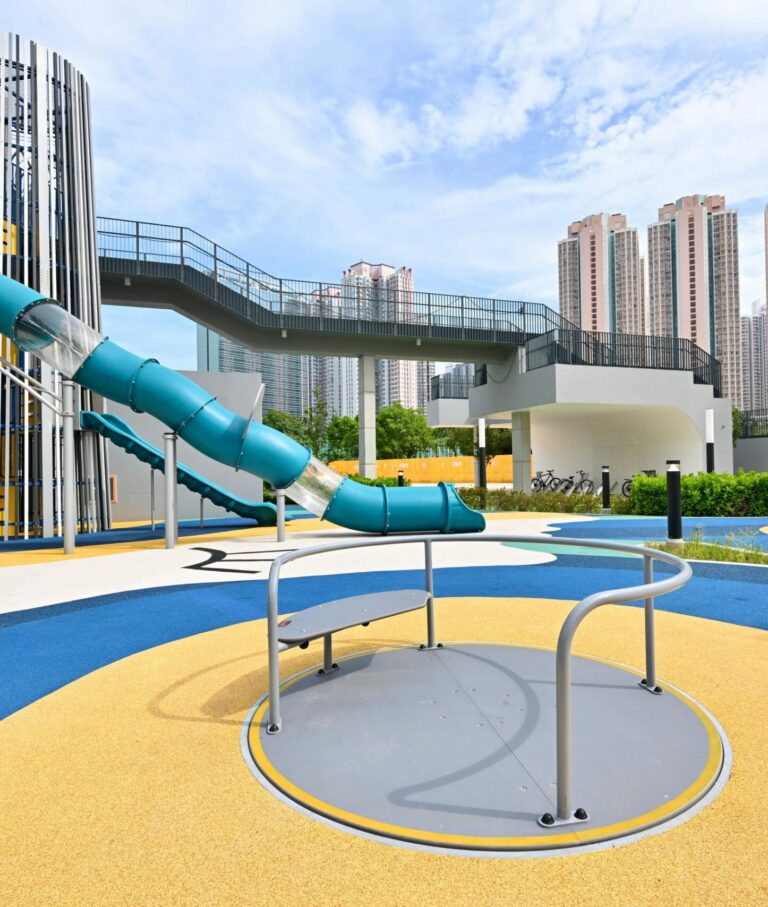 Blue tube slide and inclusive carousel at Tin Sau Road Playground in Tin Shui Wai