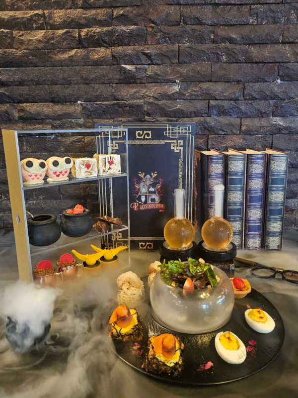 afternoon tea featuring devilled eggs, spell books, smoke and owl cakes