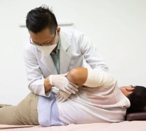 Image of physician helping patient stretch - Jin TCM Clinic - tcm clinic singapore