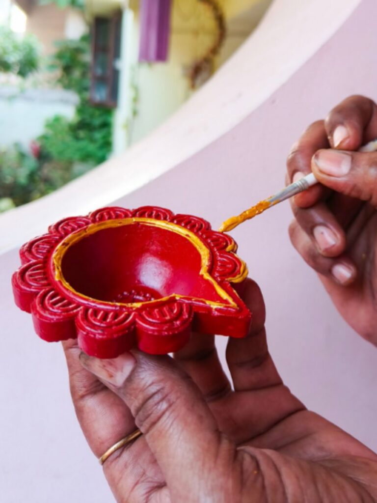 Image of person painting a terracotta diya - deepavali event singapore