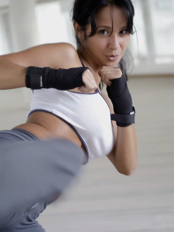woman doing a kick in a boxing class in singapore little steps