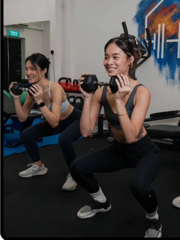 two women doing a fitness class with weights