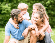 mum, dad and two children having fun in the park little steps