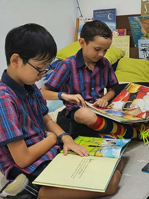 two students reading books in the school's reading corner