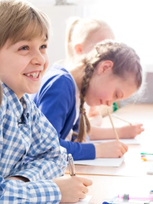 boy and girl sitting at a desk in blue and white clothing