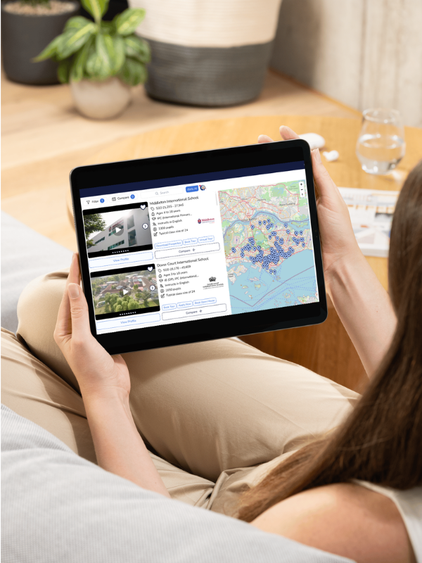 woman sitting on lounge looking at her tablet and exploring schools