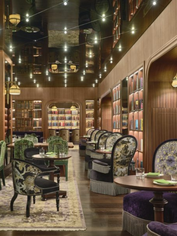 internal view of cultivate cafe showing round back chairs in green and book shelves on the walls