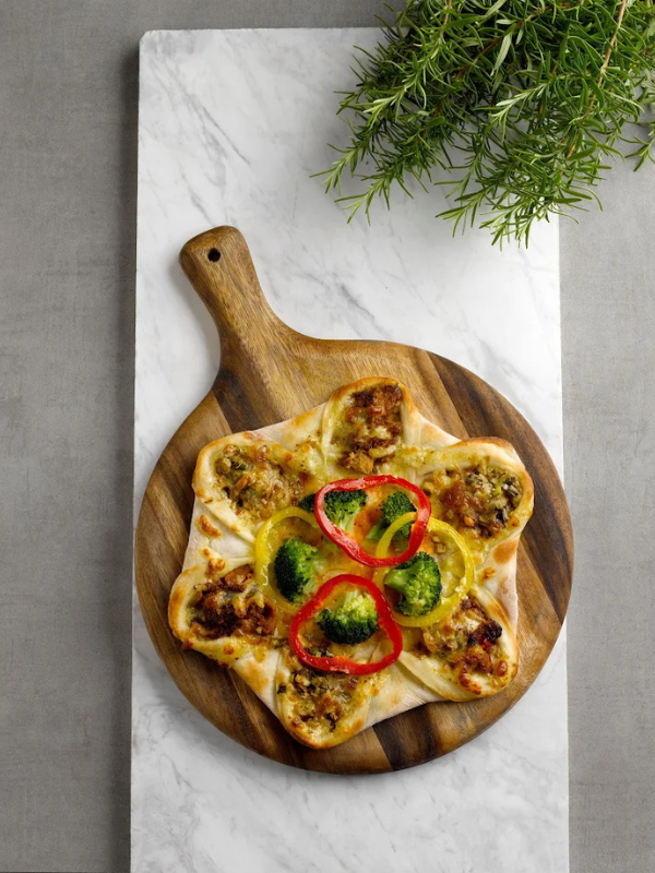 vegetarian pizza on a marble cutting board with herbs