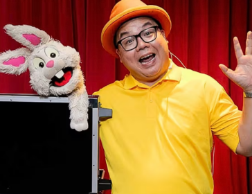 magician in yellow t-shirt with a rabbit puppet