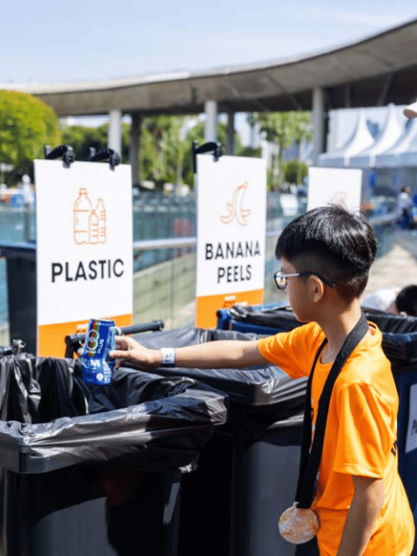 Young runner putting waste in the plastic waste bin