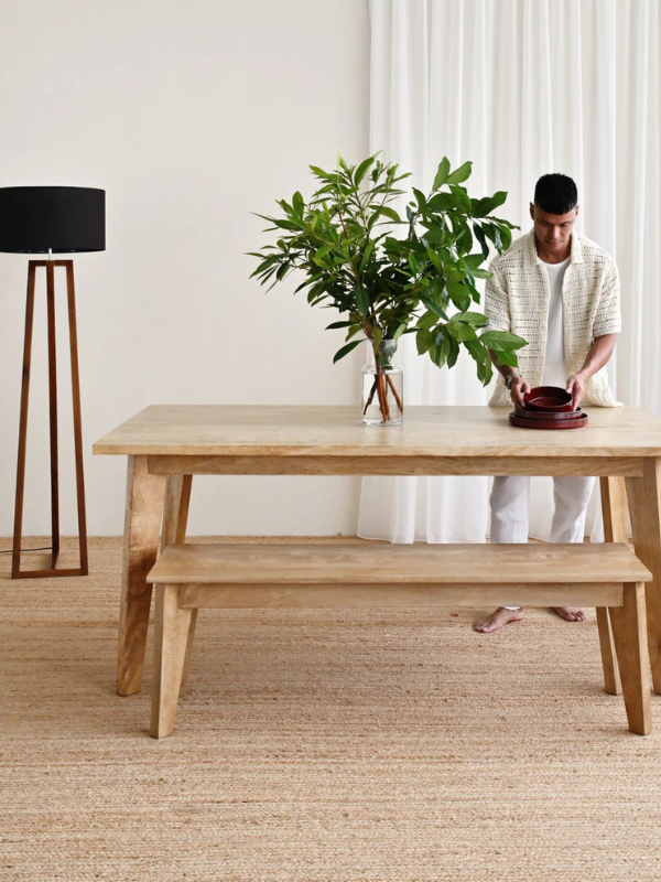 Natural wooden table and bench chairs with high lamp and black lamp shade