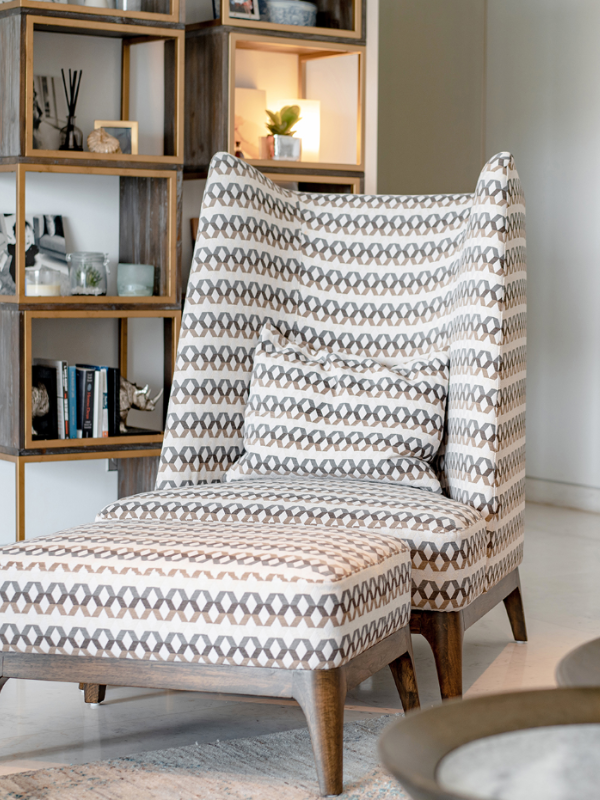 winged back chair in beige and cream colored fabric in a lounge room setting