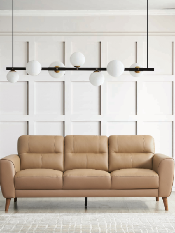 Lighter brown 3 seater lounge against a white wall