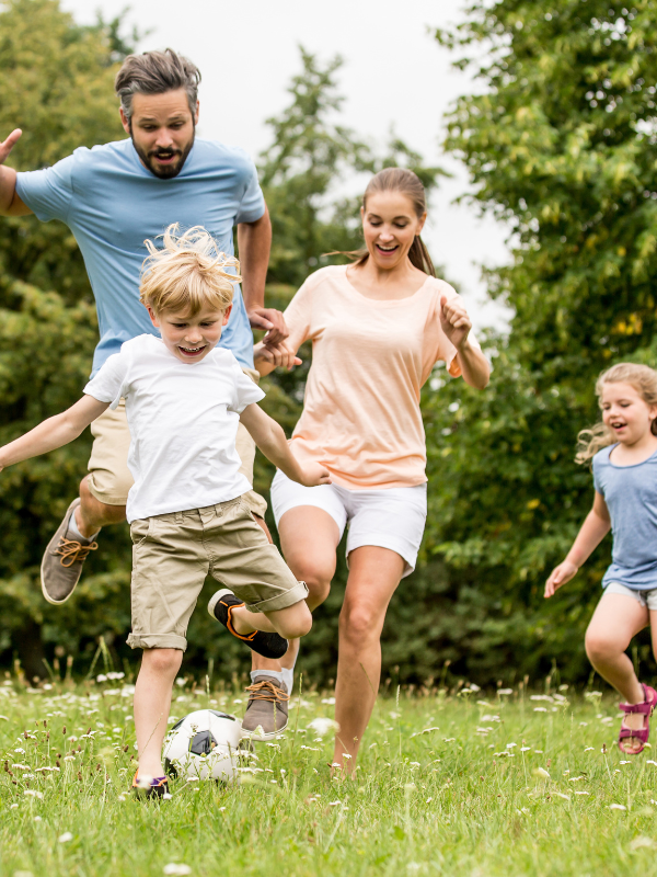 family playing soccer in the park