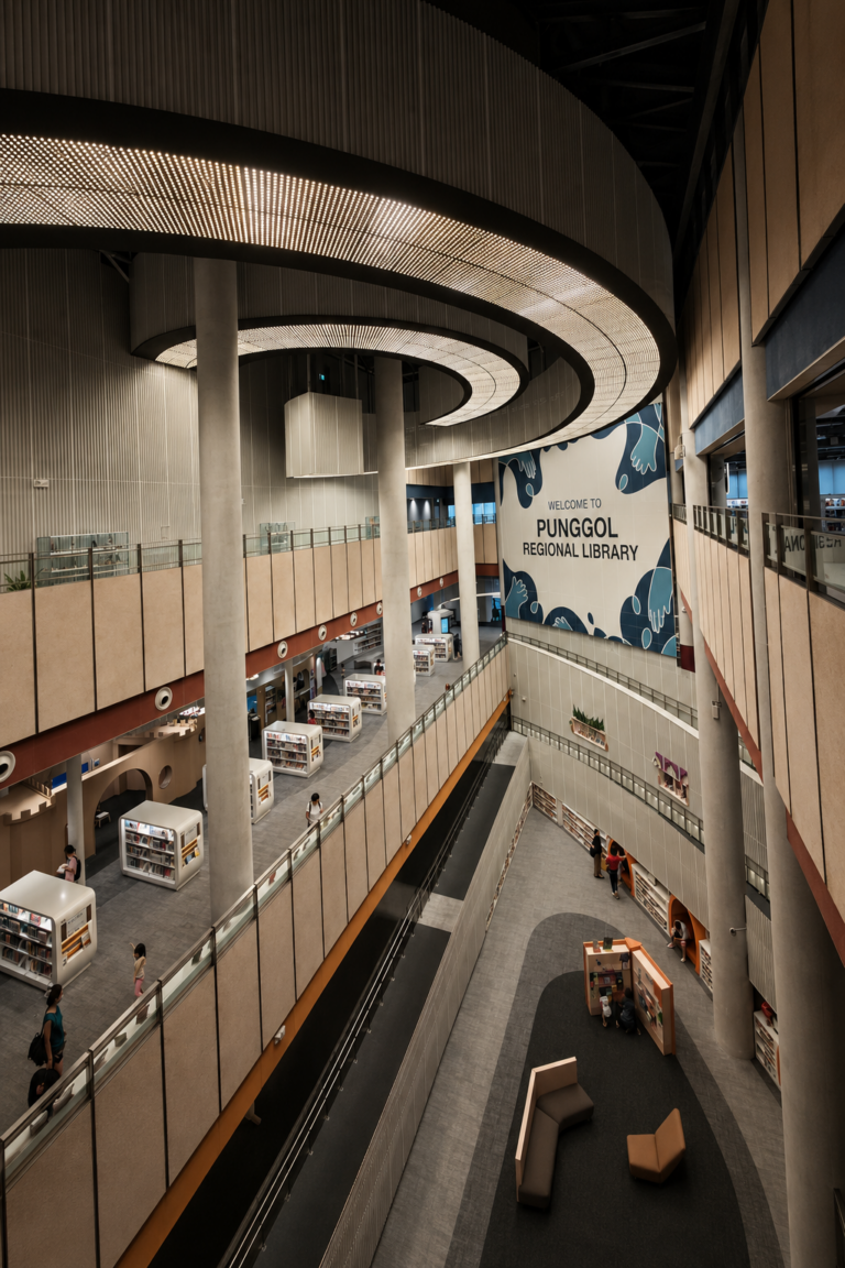 The modern, multi-story atrium of Punggol Regional Library in Singapore with curved architectural lighting and integrated technology spaces
