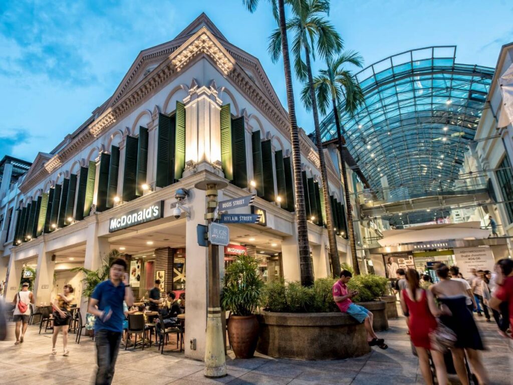 Families exploring the iconic glass-roof shopping streets inside Bugis Junction Singapore.