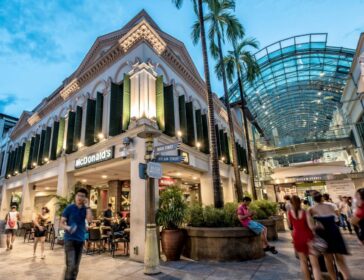 Families exploring the iconic glass-roof shopping streets inside Bugis Junction Singapore.