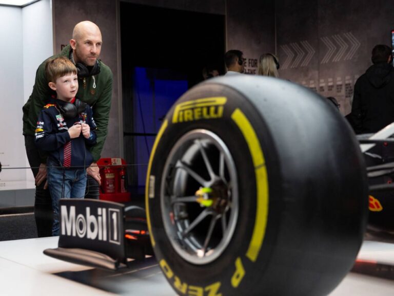 Family exploring the Formula 1® Exhibition with iconic Formula 1 race cars and interactive displays