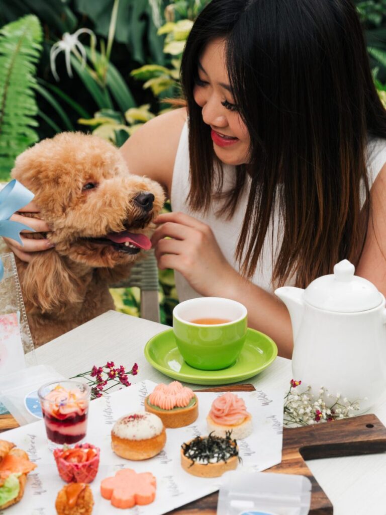 Image of woman and dog at Wildseed Cafe - cafe in park singapore