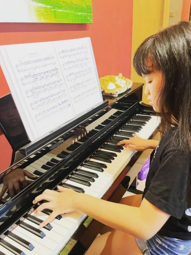Image of girl playing piano - enrichment class singapore