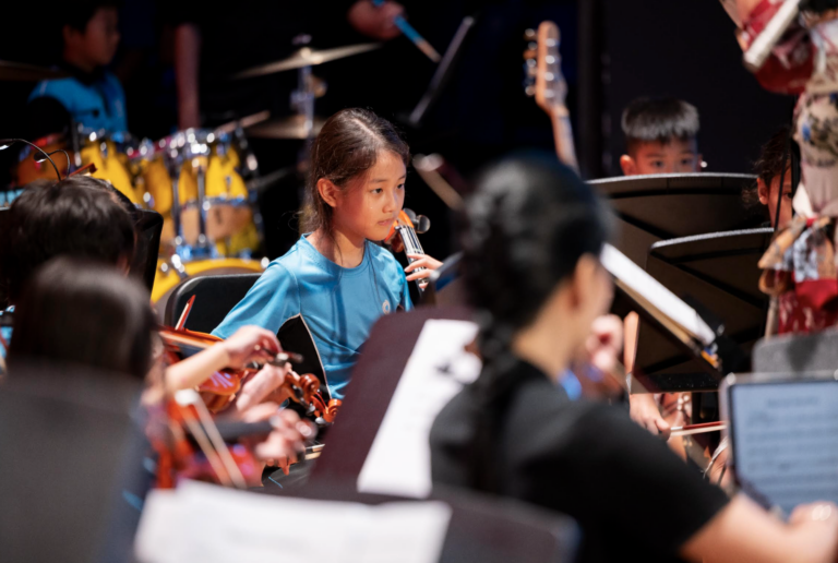 Student performing music as part of authentic, real-world learning at Nexus International School Singapore