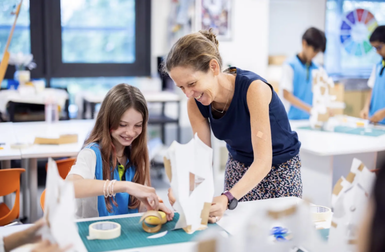 Teacher helping a student with a hands-on project at Nexus International School Singapore