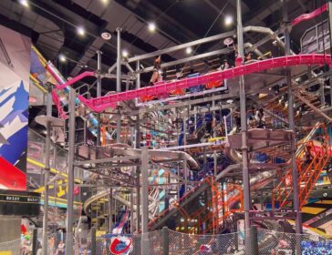 Multi-level ropes course with a pink Rail Fly track and silver slides at BE1ST indoor adventure park in Pudong, Shanghai