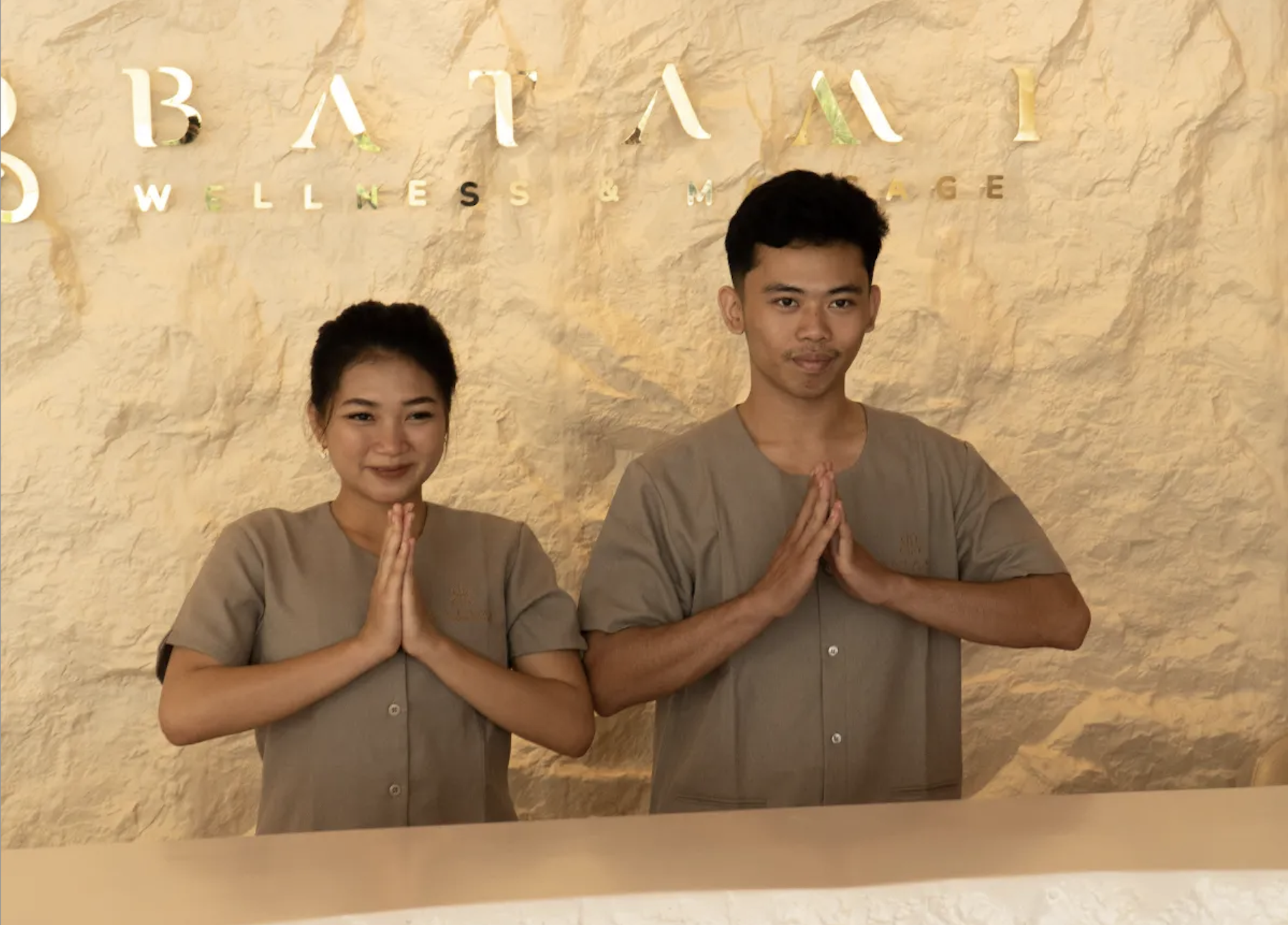 Smiling staff greeting guests at the Level 2 reception desk of Batam 1 Wellness & Massage in Batam