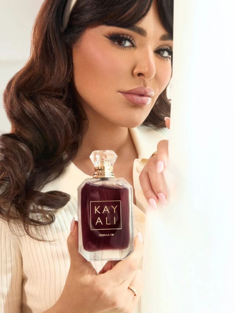 Image of woman holding Kayali's Vanilla 28 perfume - christmas gift singapore