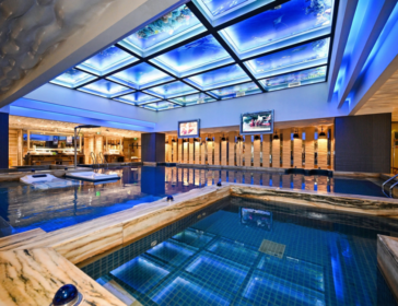 Heated indoor hot spring pool under a glowing blue glass ceiling at Aqila Hot Spring in Nanshan, Shenzhen