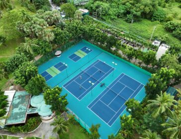 Aerial view of the pickleball and tennis courts among palm trees at Pullman Phuket Karon Beach Resort